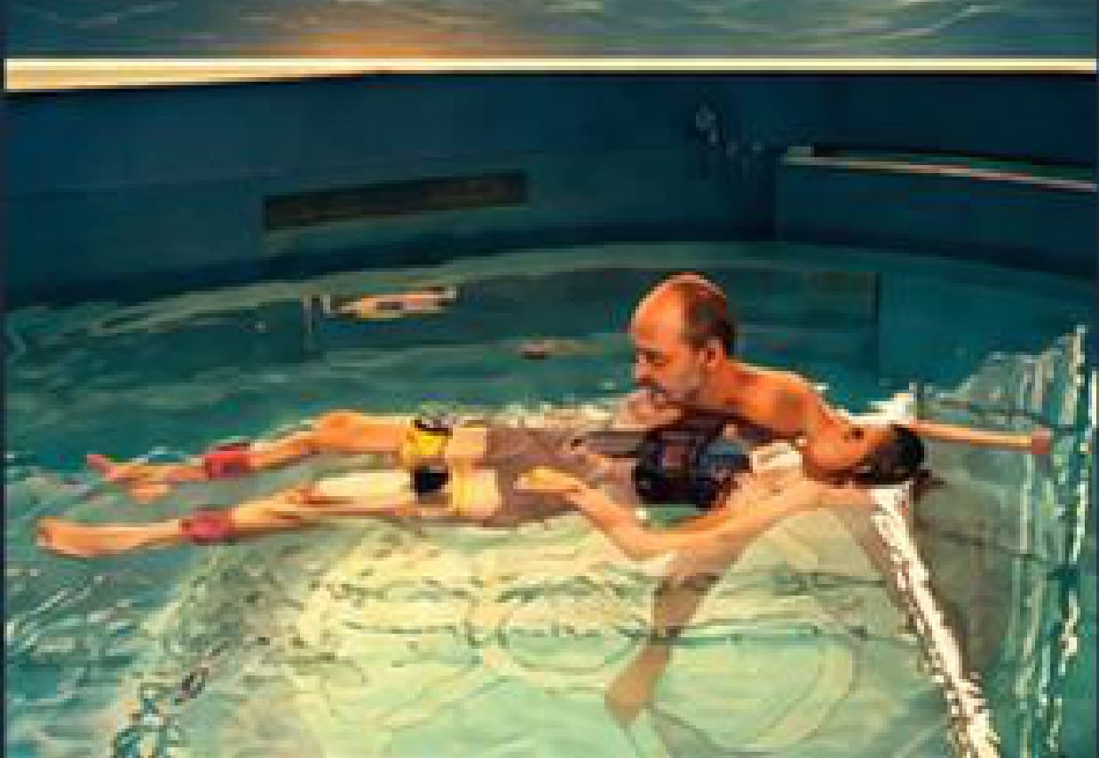 A Watsu hydrotherapy session, with a practitioner supporting a guest floating in warm water.
